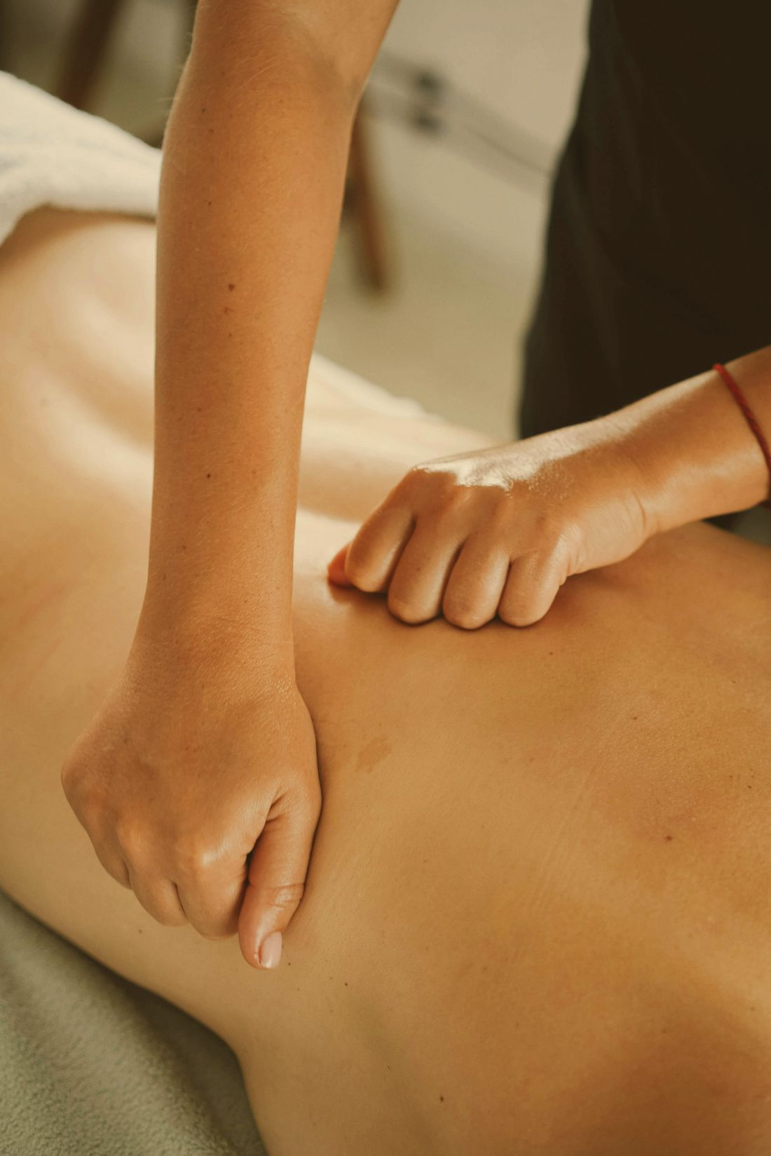 Mains qui massent le dos en lumière douce